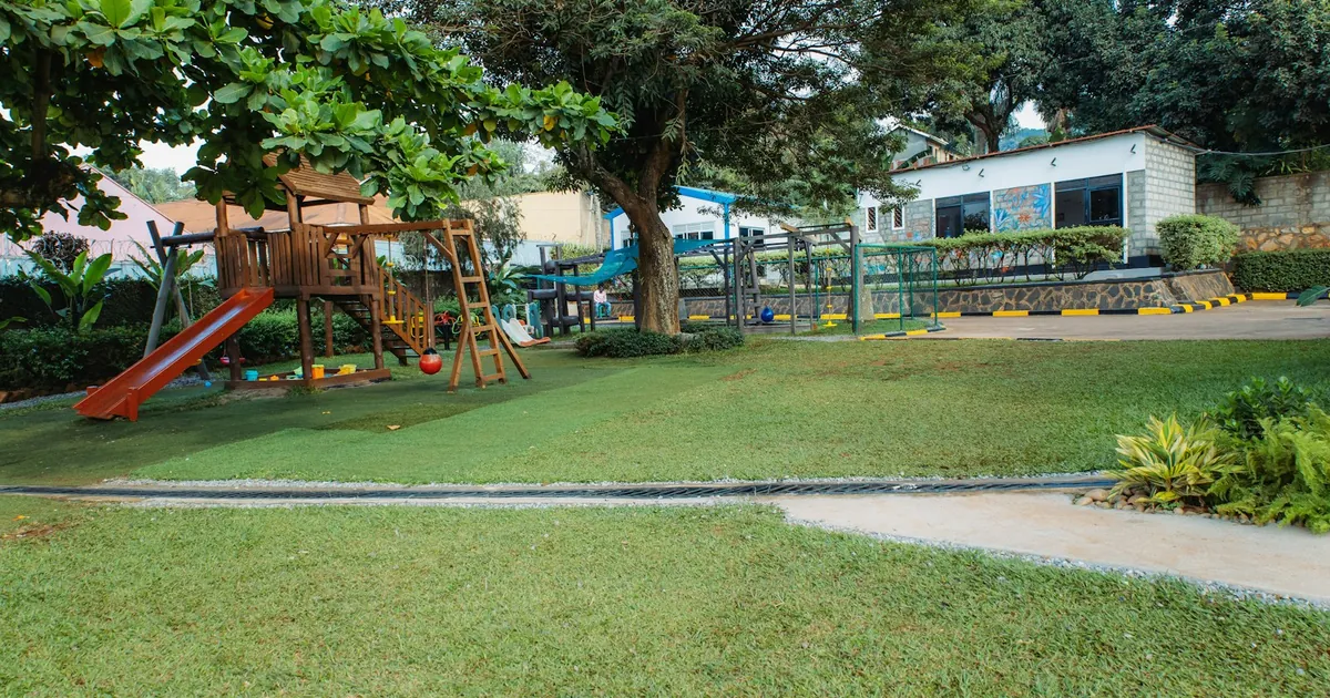 Playground swings and slides beside an open grassy area